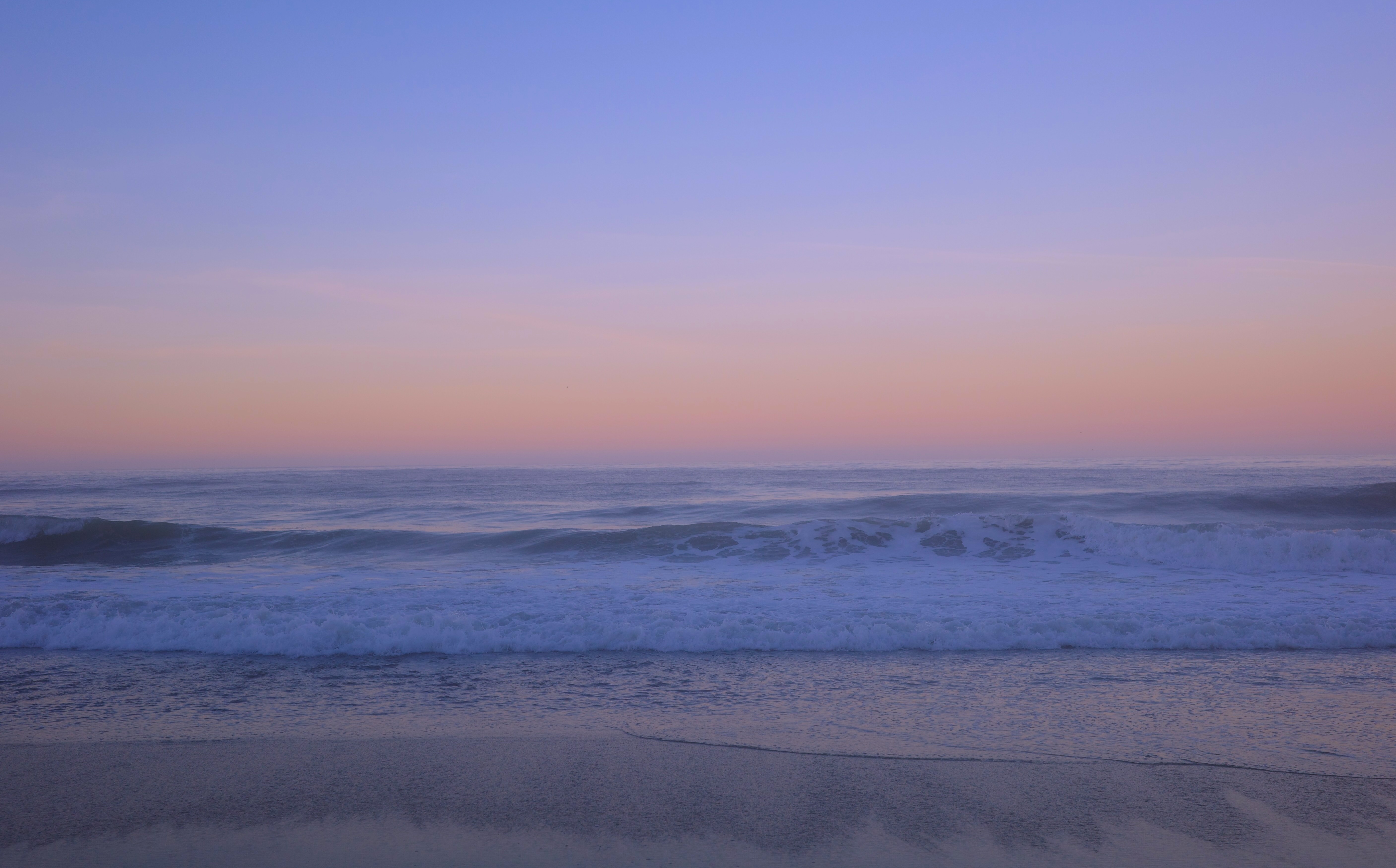 Ocean waves beneath a soft pink and blue sunrise sky at Wildcat Campground in Point Reyes National Seashore